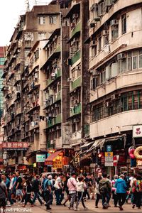 People on street against buildings in city