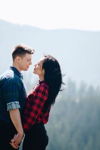 Young couple standing against sky