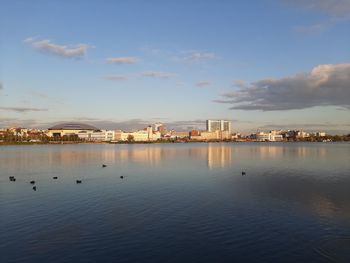 View of city by river against sky