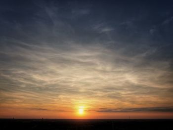 Scenic view of dramatic sky over silhouette landscape