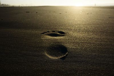 Close-up of footprints on sand at beach