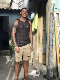 Portrait of smiling young man standing against built structure