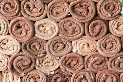 Full frame shot of stacked rolled brown and beige towels