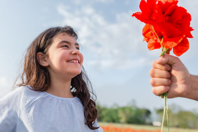 Young woman holding yellow flower