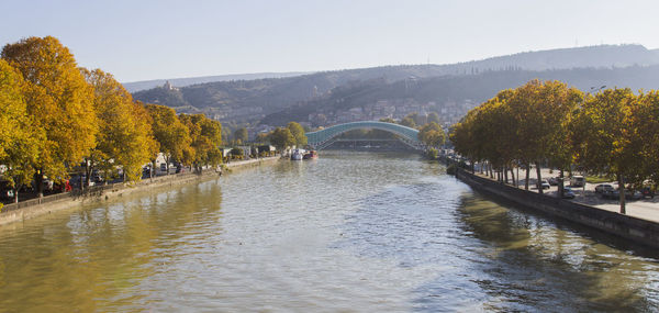 Bridge over river against clear sky during autumn