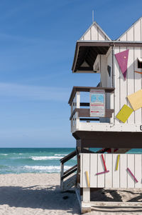 Lifeguard hut on beach against sky