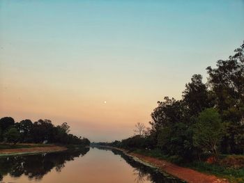 Scenic view of lake against clear sky at sunset