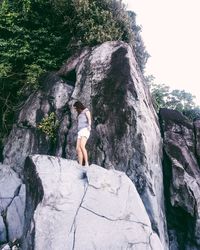 Low angle view of woman standing on rock