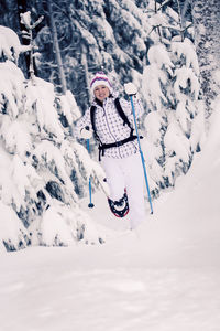 Woman skiing on snow covered field