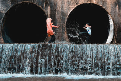 Siblings playing with water