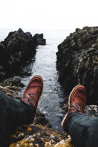 Low section of man standing on cliff