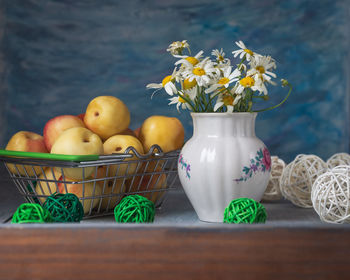 Fruit in a box. ripe nectarines and white daisies in a rustic kitchen