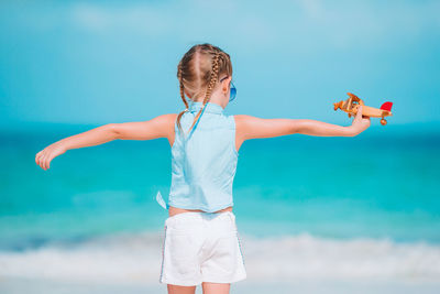 Full length of girl standing against sea