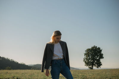 Woman standing on field against clear sky