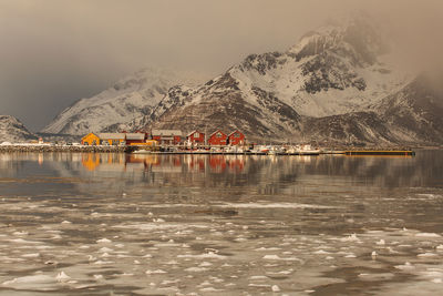 Scenic view of lake by snowcapped mountains against sky