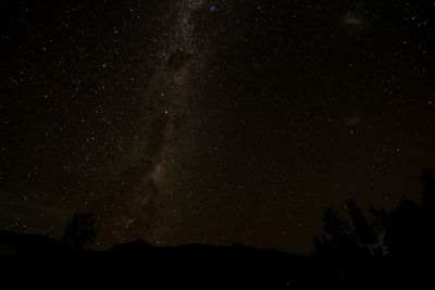 Low angle view of silhouette mountain against star field