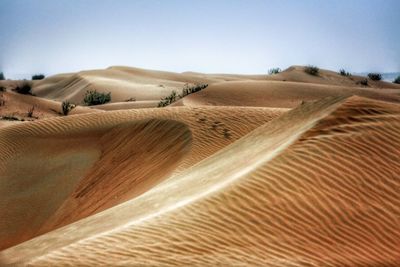 Sand dunes in desert against clear sky