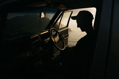 Silhouette man sitting in car