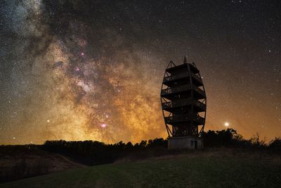 Low angle view of built structure against star field at night