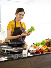 Young woman preparing food on table at home