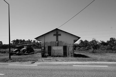 Houses by street against clear sky