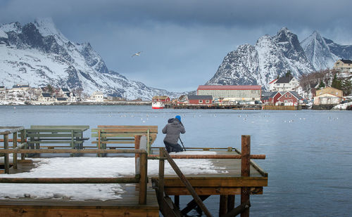 Woman on snowcapped mountain against sky during winter