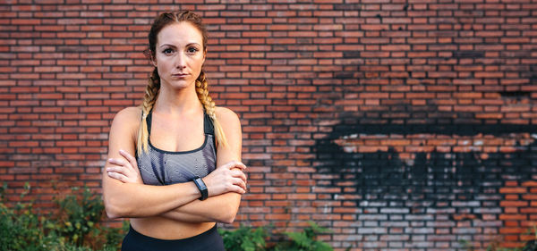 Woman standing against brick wall