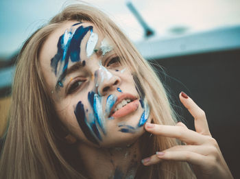 Portrait of beautiful young woman with painted face