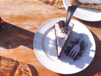 High angle view of chocolate cake slice served in plate with fork