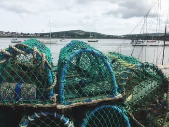 Fishing boats moored at harbor against sky