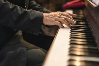 Midsection of man playing piano