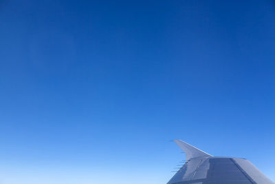 Aircraft wing against clear blue sky