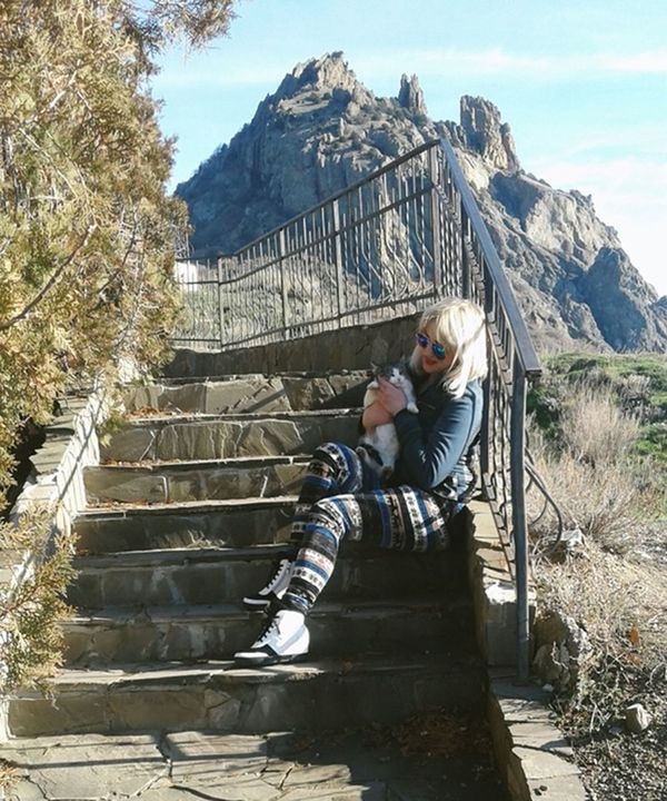 WOMAN ON STEPS AGAINST MOUNTAIN