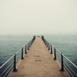 Pier on sea against clear sky