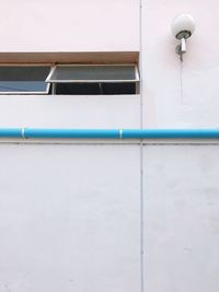 Low angle view of white building against blue wall