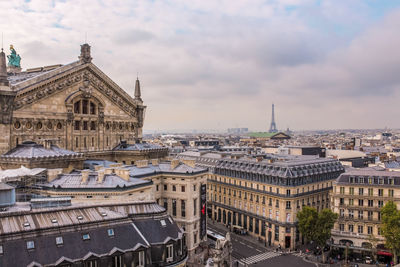 Buildings in city against cloudy sky