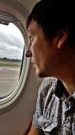 Close-up portrait of man looking through car window
