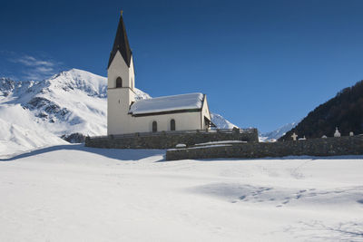 Church on snowcapped mountain against sky