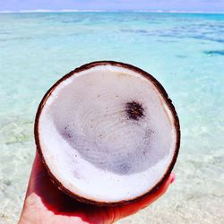 Close-up of hand holding ice cream on beach