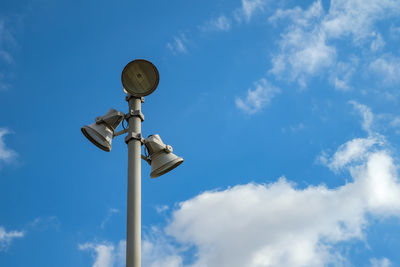 Low angle view of lighting equipment against blue sky