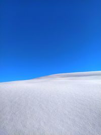 Scenic view of desert against clear blue sky