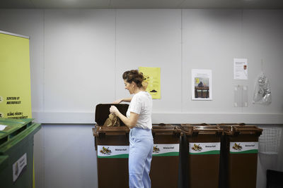 Woman putting waste in recycling bins