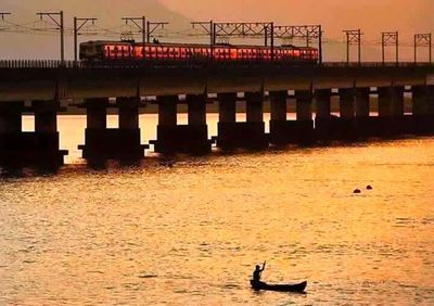 Boats in river at sunset