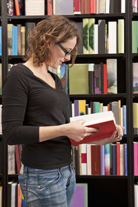 Woman reading book in bookstore