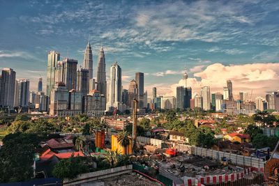 Panoramic view of buildings in city against cloudy sky