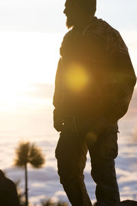 Low angle view of man standing against sky during sunset