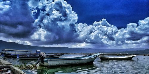 Boats moored in sea against sky