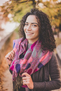 Close-up portrait of woman with curly hair standing outdoors