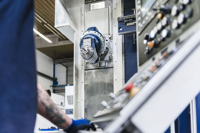 Close-up of man operating machine in industrial factory