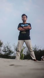 Portrait of young man standing against sky